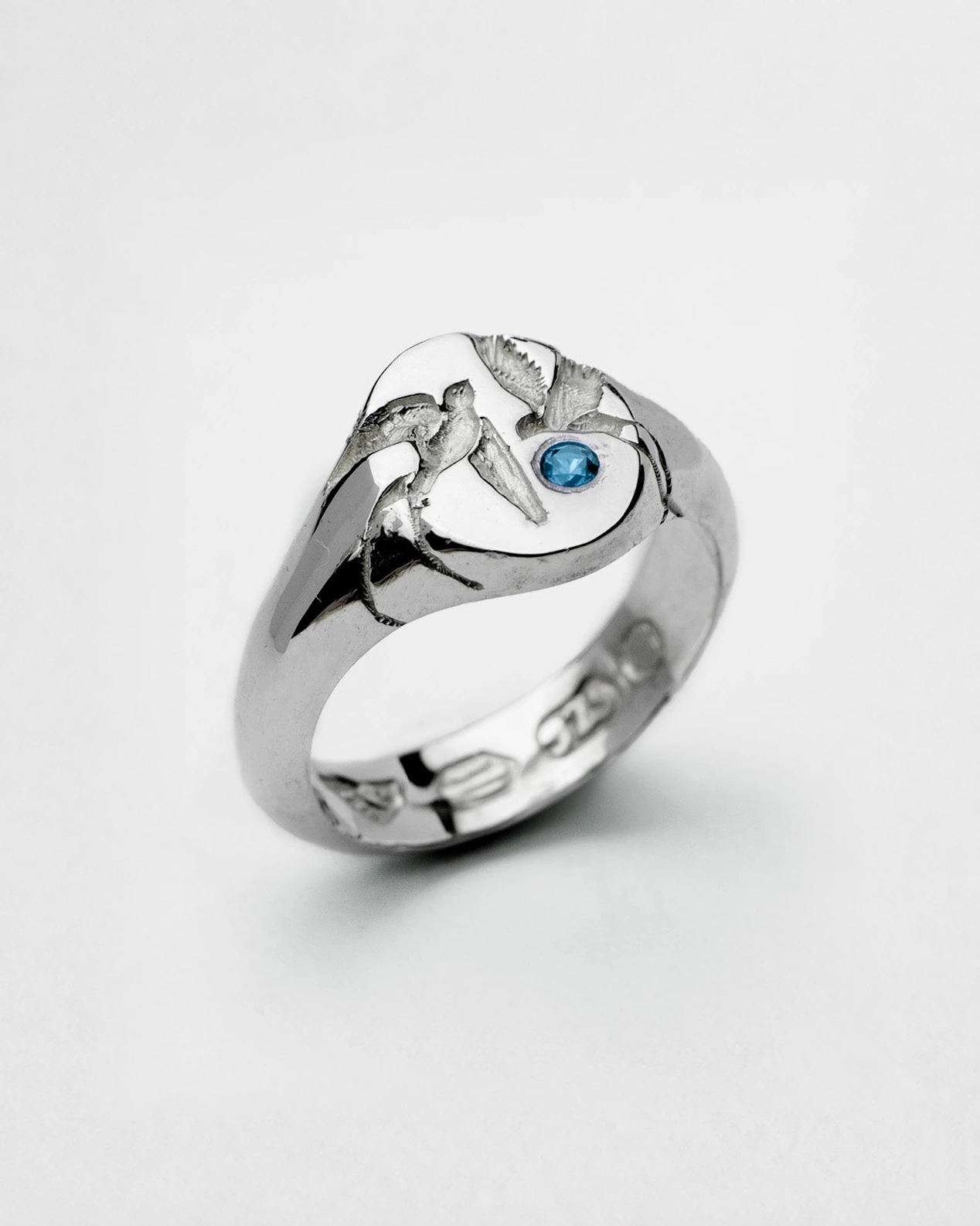 Loyal Signet in sterling silver — angled front showing swallow engraving and blue stone