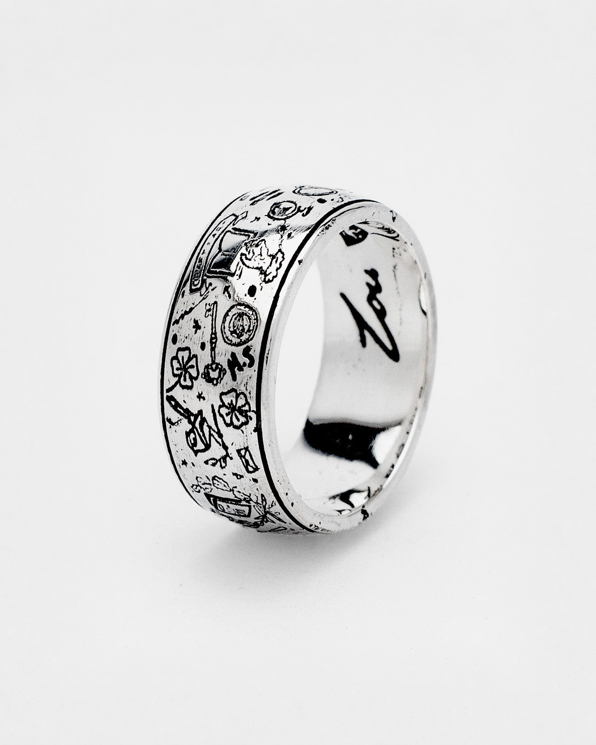 The Grad Ring in sterling silver — angled view of the wide engraved band
