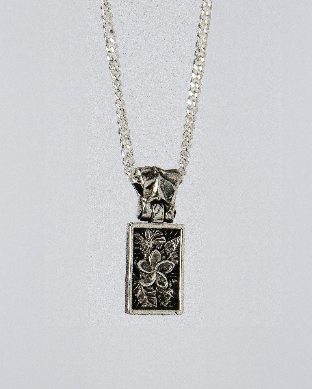 Nascence Pendant in sterling silver — front view of the frangipani engraving on chain